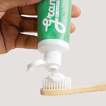 Grants Mild Mint toothpaste being squeezed onto a bamboo toothbrush