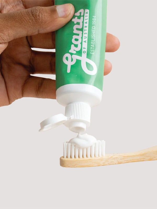 Grants Mild Mint toothpaste being squeezed onto a bamboo toothbrush