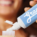Grants Whitening plus HA toothpaste applied to a bamboo toothbrush