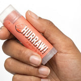 Hand holding Hurraw! Organic Lip Balm - Grapefruit 4.8g