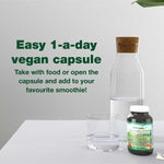 Green Nutritionals Vegan Multivitamin beside a glass of water
