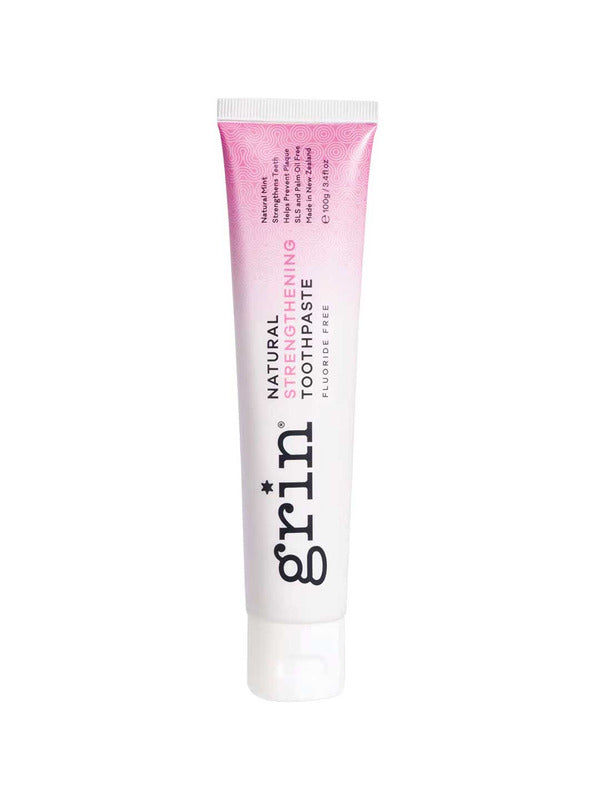 Grin Natural Strengthening toothpaste tube with a pink-to-white gradient, dark vertical Grin lettering and a white flip-top cap.
