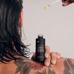 Model applying Vanessa Megan Argan and Coconut Hair Oil to wet hair