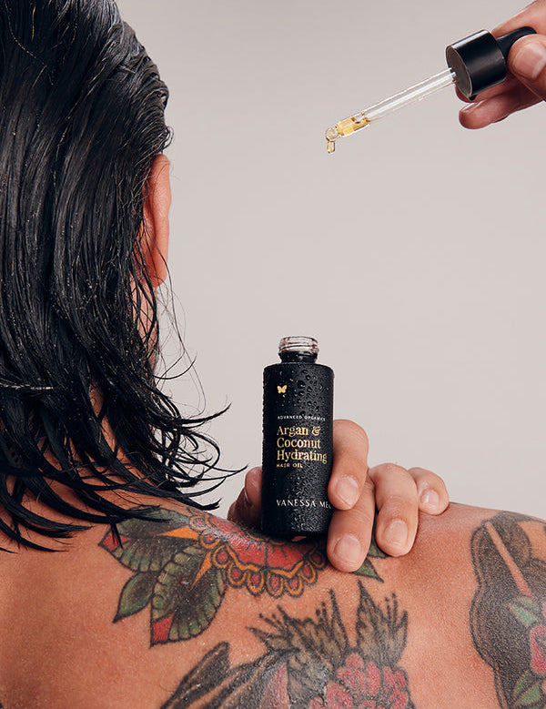 Model applying Vanessa Megan Argan and Coconut Hair Oil to wet hair