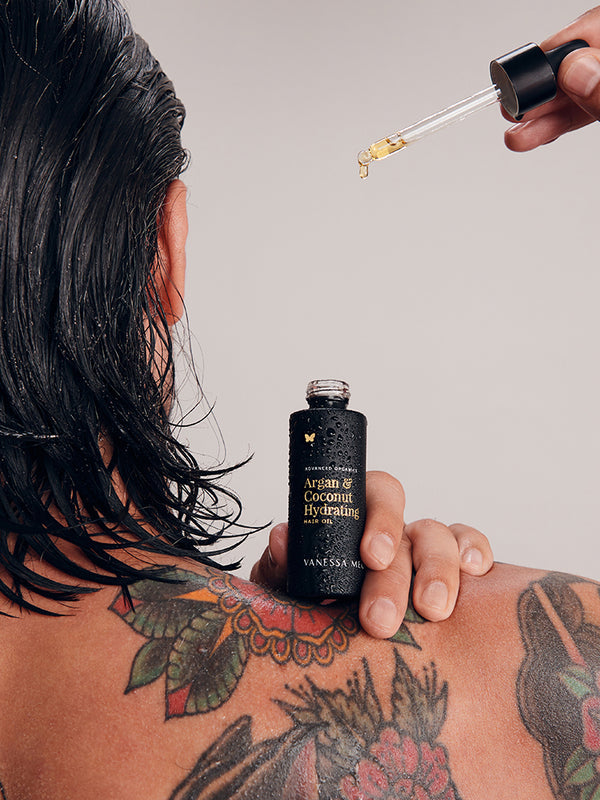 Model applying Vanessa Megan Argan and Coconut Hair Oil to wet hair