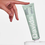 Hand reaching for Davids Whitening and Antiplaque Peppermint Toothpaste