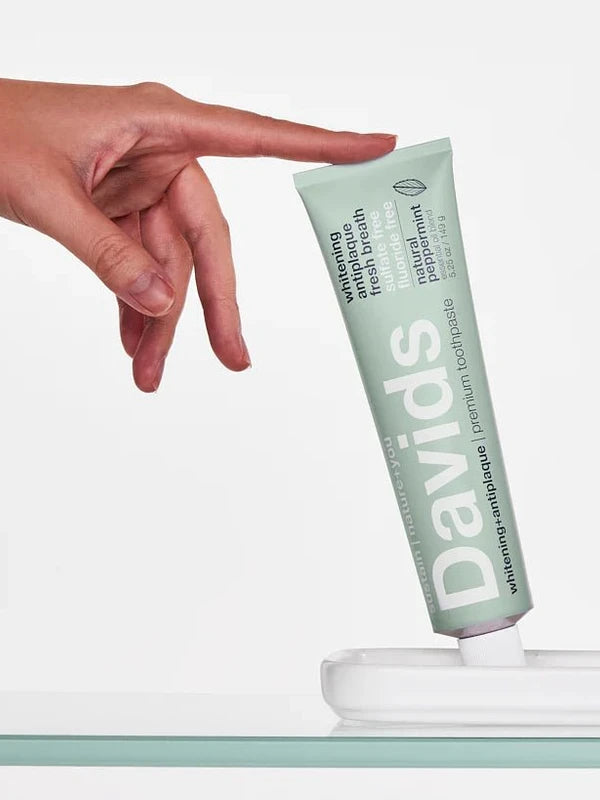 Hand reaching for Davids Whitening and Antiplaque Peppermint Toothpaste