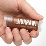 Hand holding Hurraw! Organic Lip Balm - Hazelnut 4.8g