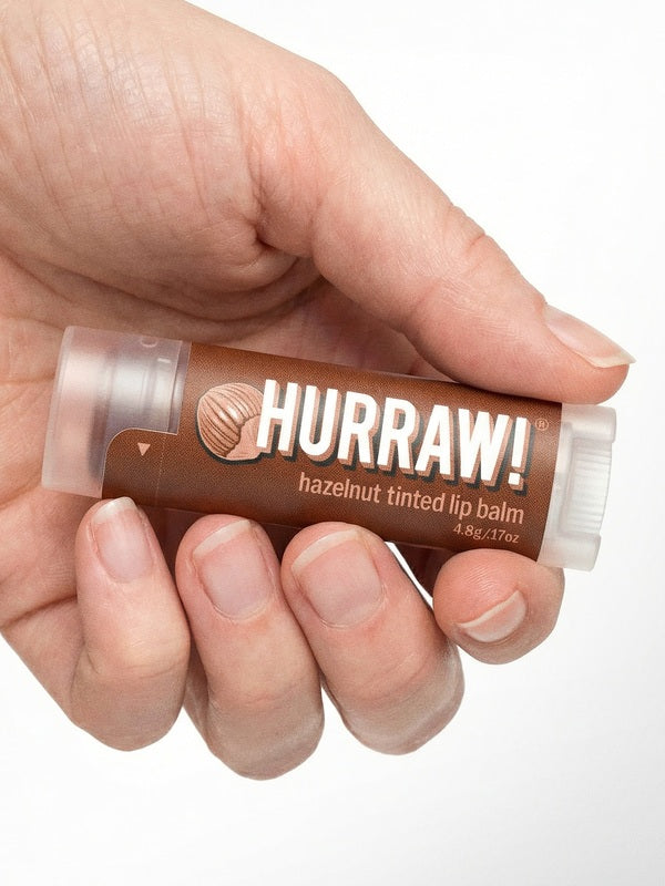 Hand holding Hurraw! Organic Lip Balm - Hazelnut 4.8g