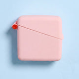 Closed pale pink Hello Caddy case on a light blue background, with rounded corners, a diagonal seam across the front and a small coral loop at the left.