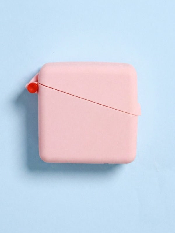 Closed pale pink Hello Caddy case on a light blue background, with rounded corners, a diagonal seam across the front and a small coral loop at the left.