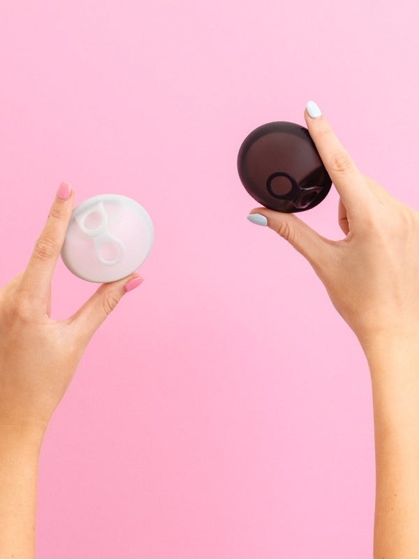 Hello Period Sea Fog and Black menstrual discs held in hand