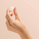Hand holding a Herbs of Gold Magnesium Chewable raspberry tablet