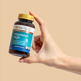 Hand holding the Herbs of Gold Magnesium Night bottle