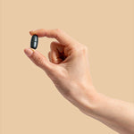 Hand holding a Herbs of Gold Magnesium Night tablet