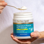 Spoon of Herbs of Gold Magnesium Powder High Strength being scooped from the tub