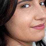 Woman wearing a glossy black-cherry lip tint, with the caption Hurraw Black Cherry Tinted Lip Balm kept visible at the lower edge.