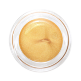 Top view of an open clear round pot of Hurraw! Gold Aura Balm, showing shimmering yellow-gold balm with a small central indentation.