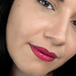 Close-up of a model wearing the bright pink shade from Hurraw! Rouge à Lèvres Plantcolour No 2, with the shade label visible.