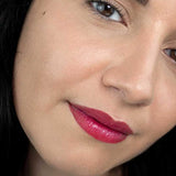 Close-up of a model wearing the bright pink shade from Hurraw! Rouge à Lèvres Plantcolour No 2, with the shade label visible.