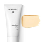 A white tube labeled Dr Hauschka Foundation 30ml is displayed beside a beige swatch of this natural, medium-coverage foundation, set against a white background.