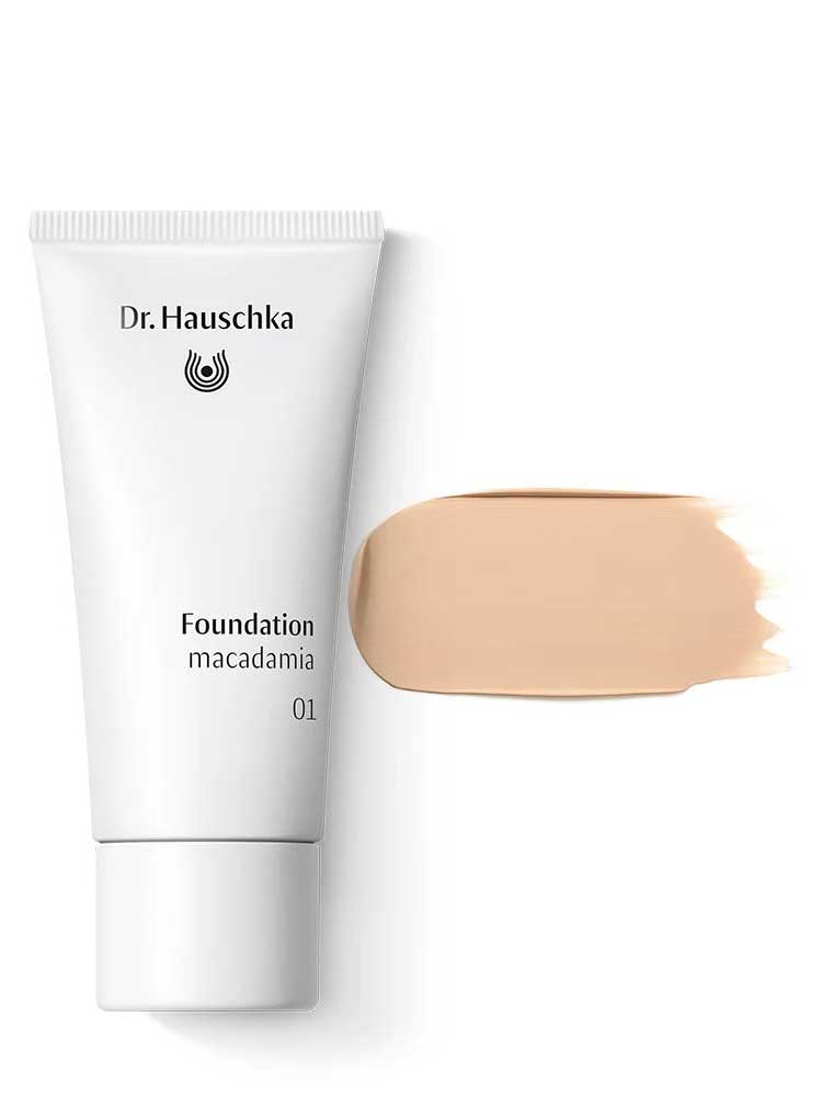 A 30ml tube of Dr Hauschka Foundation is displayed in the shade macadamia 01, alongside a swatch of its light beige, natural medium coverage formula on a white background.