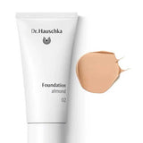A white tube of Dr Hauschka Foundation 30ml is displayed beside a smear of beige, medium coverage natural foundation on a white background.