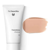 A white tube of Dr Hauschka Foundation 30ml is placed next to a beige natural foundation swatch, both offering medium coverage, on a white background.