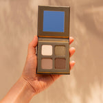 Woman’s hand holding INIKA Organic Eyeshadow Quad in Wind