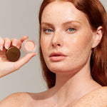 Model wearing and holding INIKA Organic Lip and Cheek Cream