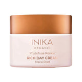 Round pale pink INIKA Phytofuse Renew Rich Day Cream jar with a broad gold lid and gold lettering naming Maca Root, against a white background.