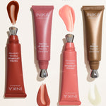 Four uncapped INIKA lip serum tubes arranged beside glossy swatches on a pale background, labelled Rosewood with red-brown serum, Peony with rose-pink serum, Blush with light pink serum and Clear with translucent serum.