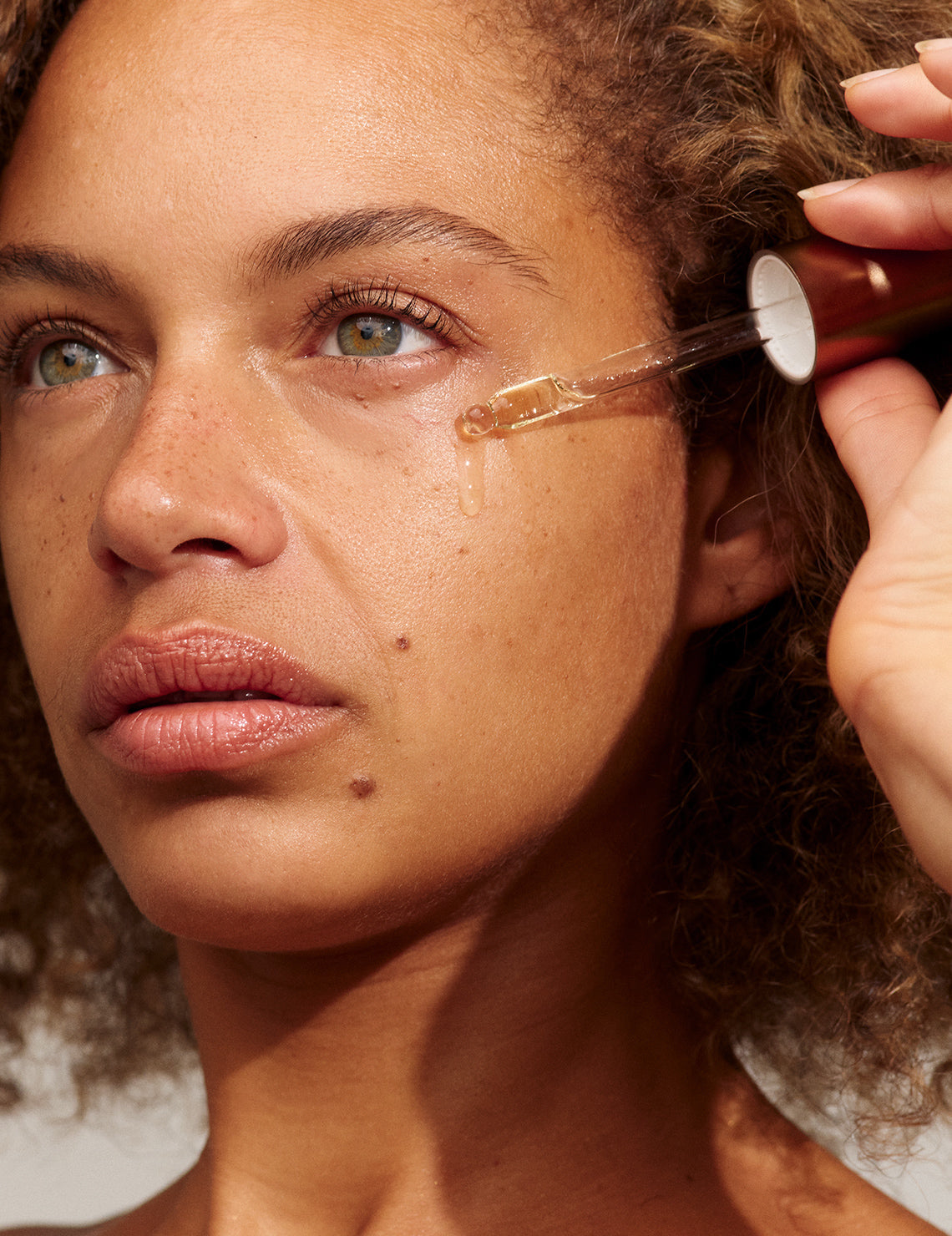 Model applying INIKA Organic Phyto-Active Face Oil