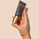 Hand holding INIKA Organic Pure Perfection Primer