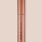 INIKA Organic Purity Lash Mascara in Black standing upright in a metallic rose-gold tube against a soft beige background.