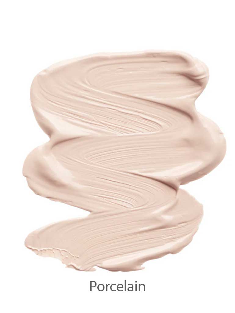 A smooth, creamy swirl of light beige INIKA Organic Sheer Coverage Concealer 10ml with a silky texture is shown on a white background. The word "Porcelain" appears below the swatch, indicating the shade.