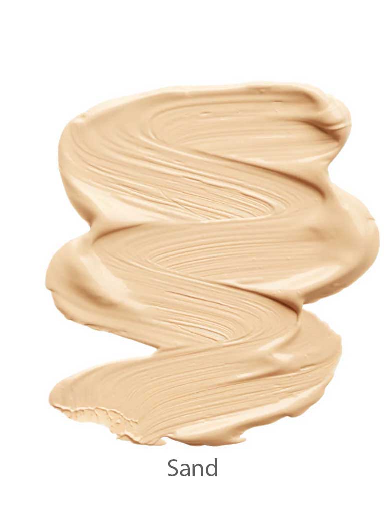 INIKA Organic Sheer Coverage Concealer 10ml shown in a beige "Sand" swatch with a smooth, creamy texture on a white background. This vegan formula offers a natural finish ideal for all-day wear.