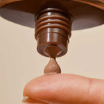 Close-up of INIKA Organic Tinted Natural Sunscreen SPF50+ being dispensed onto a fingertip from the open tube.