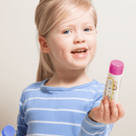 Child holding Jack N' Jill Berries and Cream toothpaste