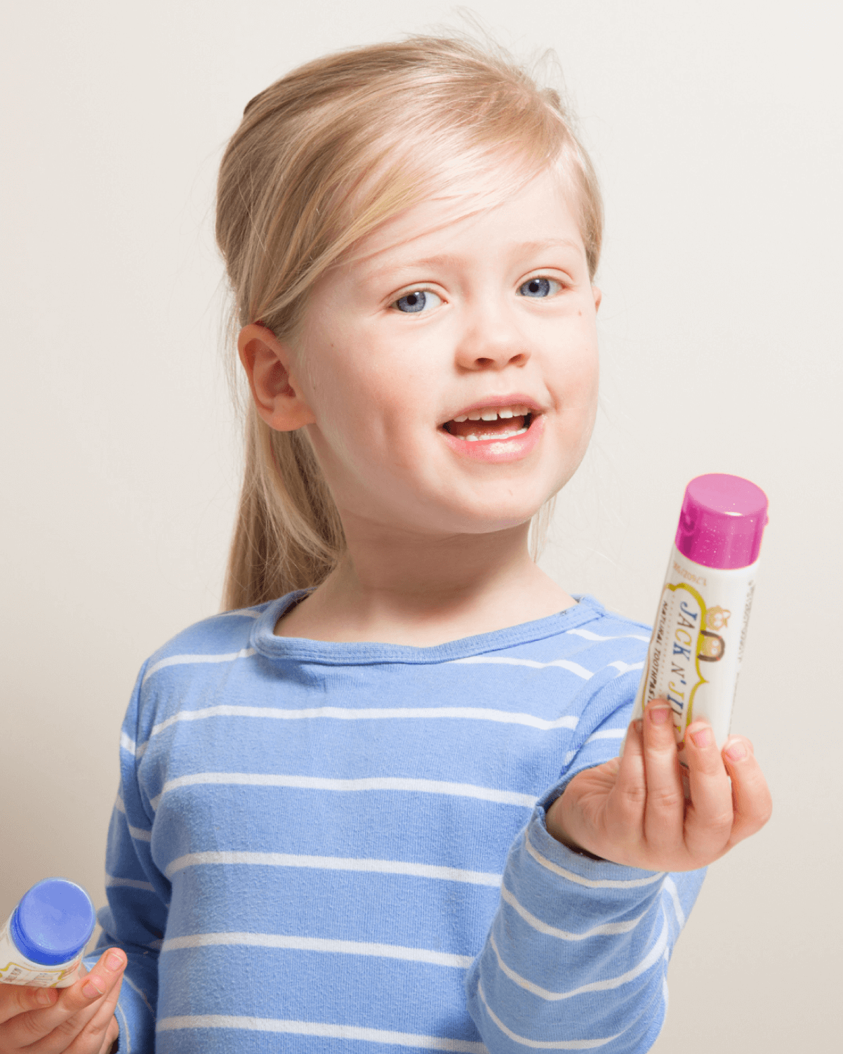Child holding Jack N' Jill Berries and Cream toothpaste