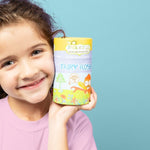 Smiling child holding a yellow box of Jack N' Jill Fairy Floss Picks beside her face against a soft blue background.