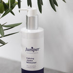 Juniper Calming Jojoba Moisturiser styled with olive leaves