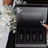 Juniper Cognitive Support and Wellbeing aromatherapy collection held open with flowers