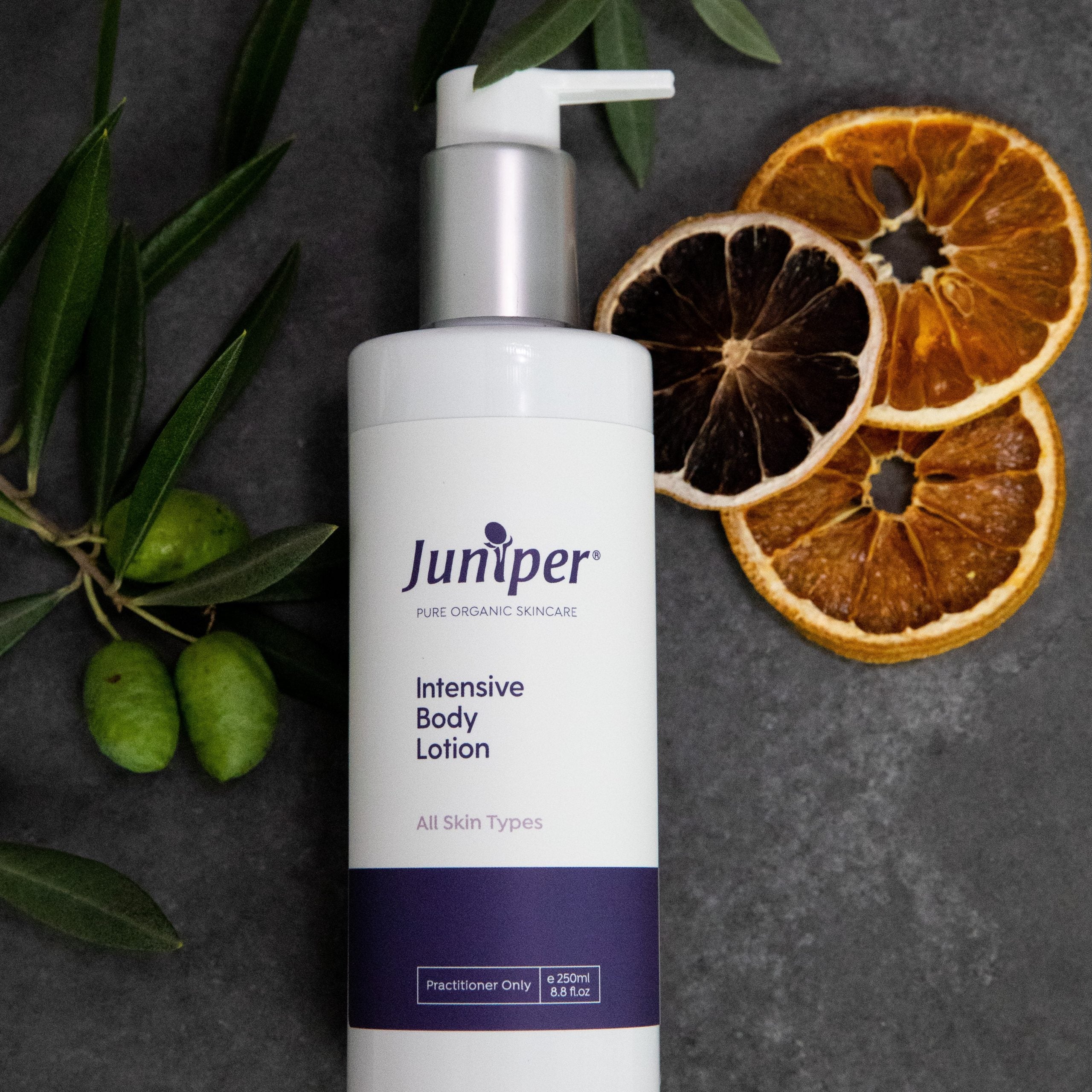 Juniper Intensive Body Lotion styled with citrus and olive branches