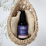 Juniper Pure Rejuvenation Oil styled in a woven pouch