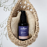 Juniper Pure Rejuvenation Oil styled in a woven pouch