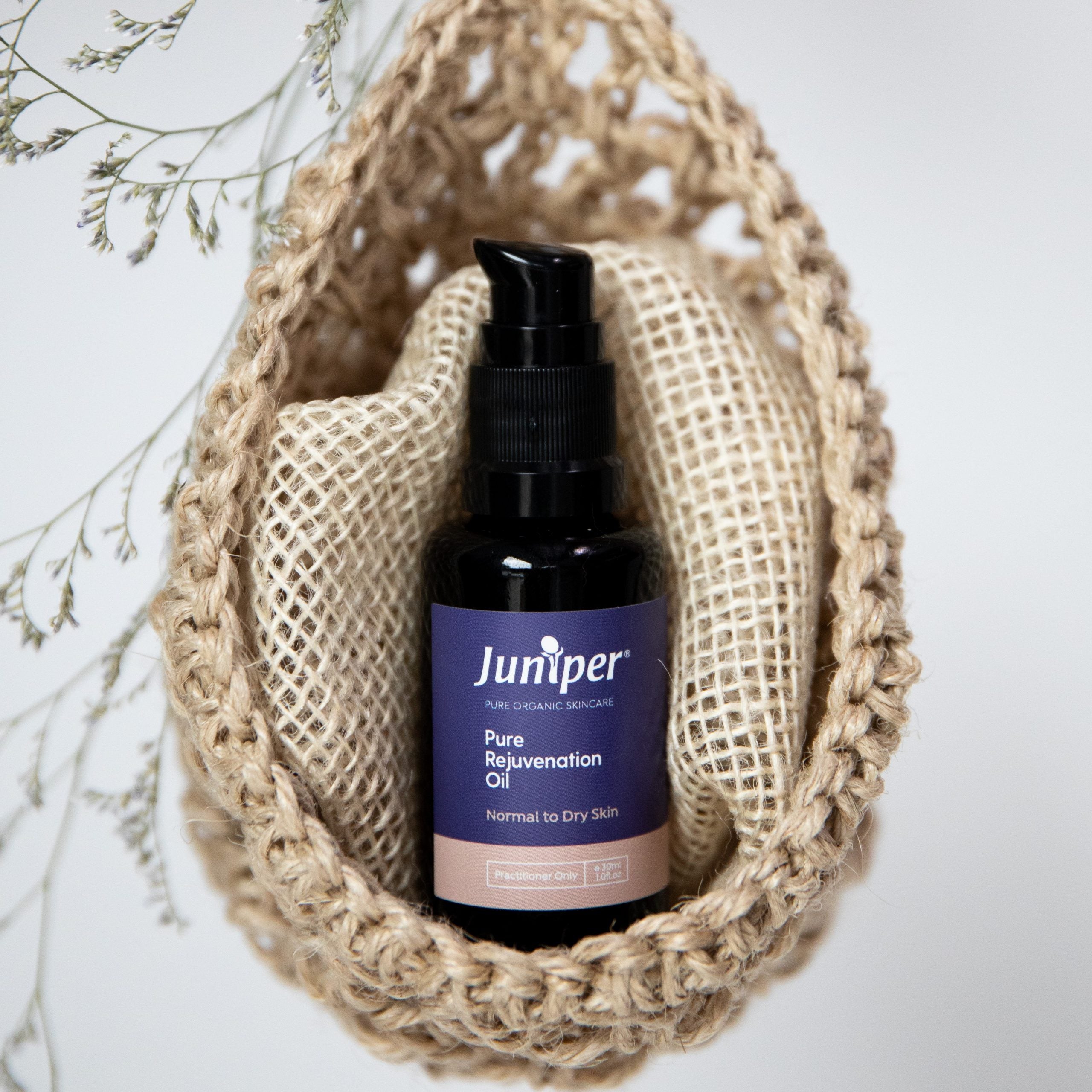 Juniper Pure Rejuvenation Oil styled in a woven pouch