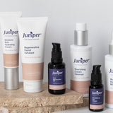 Juniper mature skincare range arranged on a natural stone platform, including the Revitalising Eye Cream with coordinating tubes and treatment bottles.
