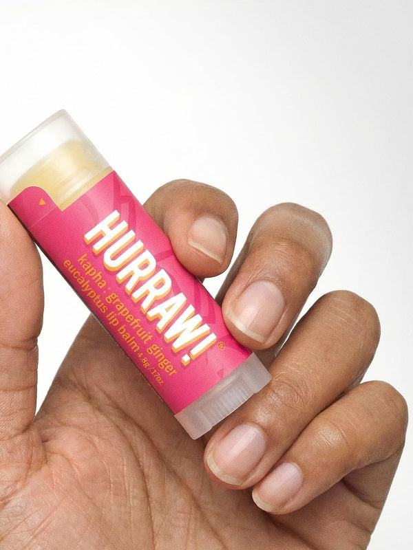 Hand holding Hurraw! Kapha Lip Balm Grapefruit Ginger & Eucalyptus 4.8g