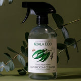 Koala Eco Bathroom Cleaner styled among eucalyptus branches on a deep green background